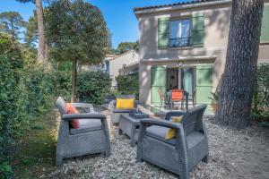 eine Gruppe von Stühlen und Tischen vor einem Haus in der Unterkunft Maison pour 4 avec terrasse - proche du centre in Saint-Brévin-lʼOcéan