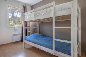 1 Schlafzimmer mit 2 Etagenbetten mit blauer Bettwäsche in der Unterkunft Maison pour 4 avec terrasse - proche du centre in Saint-Brévin-lʼOcéan