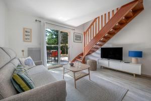 ein Wohnzimmer mit Sofa und Fernseher in der Unterkunft Maison pour 4 avec terrasse - proche du centre in Saint-Brévin-lʼOcéan