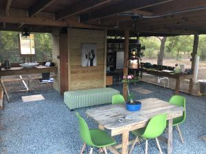 Las PalmasLas Palmas Cottage - Serene Eco Retreat的庭院配有木桌和绿色椅子