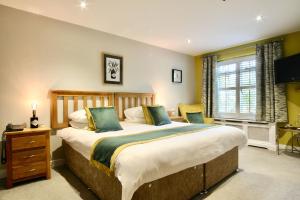 a bedroom with a large bed and a window at The Wensleydale Heifer in Leyburn