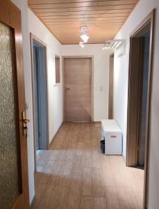 an empty hallway with a wooden door and a floor at Cebullas Ferienwohnung in Herzberg am Harz