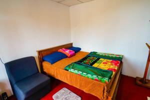 a small bedroom with a bed and a chair at Himalaya cabin in Nuwara Eliya