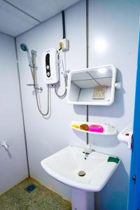 a bathroom with a white sink and a shower at Himalaya cabin in Nuwara Eliya