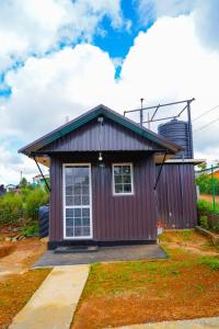 a small purple house with a windmill in the background at Himalaya cabin in Nuwara Eliya