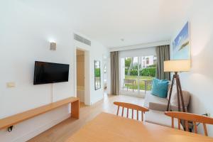 a living room with a television and a couch at Apartamentos Caprice Playa de Alcudia in Port d'Alcudia