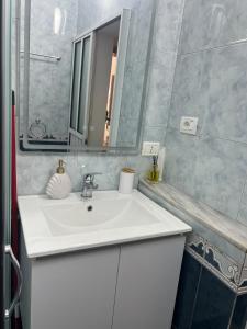 a bathroom with a white sink and a mirror at Sea view Captain Apartment Durres in Durrës +58 photos