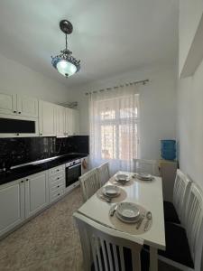 a kitchen with a white table and chairs and a dining room at Sea view Captain Apartment Durres in Durrës