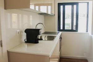 a small white kitchen with a sink and a sink at Fish Village Apartments II in Vila Nova de Gaia