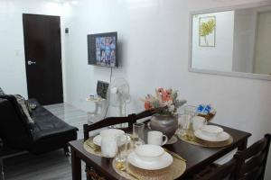 a dining room with a table with dishes on it at EC Tamayo House Rental in Bangad