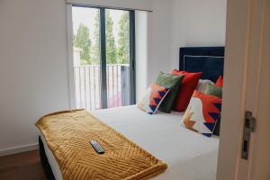 a bedroom with a bed with a remote control on it at Fish Village Apartments II in Vila Nova de Gaia