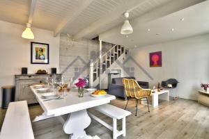 a dining room and living room with a white table at LocaLise - M5 - Maison de vacances sur le port de Lechiagat - terrasse entièrement close - Wifi inclus - Draps inclus - Animaux bienvenus in Tréffiagat