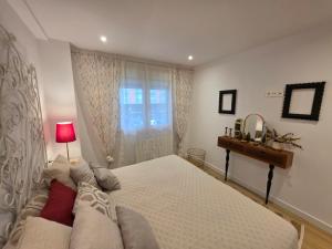 a bedroom with a bed and a table and a window at Avilés Luce B - 3 habitaciones - 2 baños - VUT-7461-AS in Avilés +28 photos