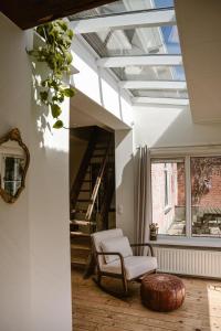 a living room with a white chair and a window at 't Buitenverblijf, gratis parkeren in Middelburg