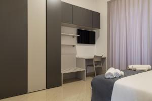 a bedroom with a bed and a desk and a tv at Palazzo Di Paola - Residenza Storica in LʼAquila