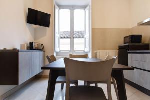 a kitchen and dining room with a table and chairs at Palazzo Di Paola - Residenza Storica in LʼAquila +10 photos