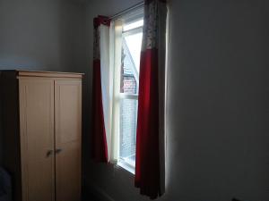 a window with a red curtain in a room at Room in town centre in Saint Helens