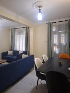 a living room with a blue couch and a table at Angie's staycation 1br apt Milimani- Fast internet, secure parking, Free netflix in Kisumu