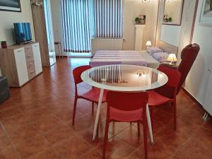 een kamer met een tafel en stoelen en een bed bij Apartments Košević in Osijek