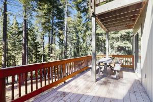 un porche en bois avec un banc sur une terrasse avec des arbres dans l'établissement Skyline Manor, à South Lake Tahoe