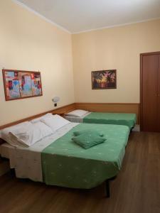 ein Schlafzimmer mit zwei Betten mit grüner Bettwäsche in der Unterkunft Hotel Aurora in Vieste + 42 Fotos
