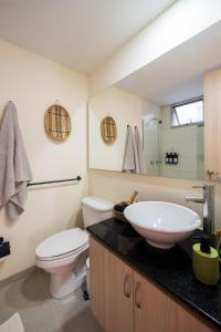a bathroom with a sink and a toilet and a mirror at Private Terrace Duplex in El Poblado in Medellín +39 photos