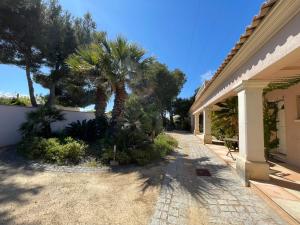 une maison avec un palmier et un trottoir dans l'établissement Grand Studio "Méjean" - Domaine Ciel et Mer, à Ensuès-la-Redonne