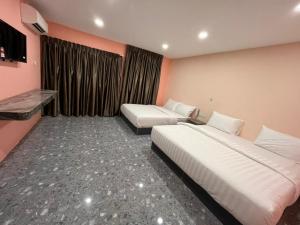 a hotel room with two beds and a window at Hotel Golden Night Star in Shah Alam