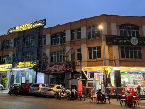 a building with cars parked in front of a street at Hotel Golden Night Star in Shah Alam