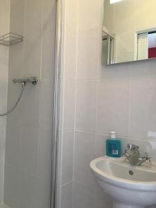 a white bathroom with a sink and a mirror at River Lodge B&B Ltd in Spalding