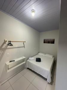 a bedroom with a bed with a black bag on it at Hotel São Miguel in Posse +1 photo