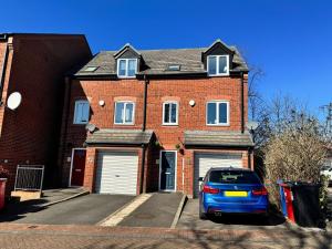 a brick house with a car parked in the driveway at Stylish 5BR Townhouse in Manor