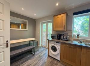 a kitchen with a washer and a sink and a washing machine at Stylish 5BR Townhouse in Manor