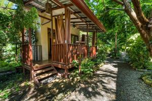 a wooden house with a porch in the woods at Bamboo River House and Hotel in Dominical +43 photos