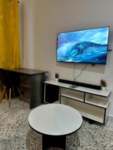 a living room with a flat screen tv on a wall at Gee Kamakis Airbnbs in Ruiru
