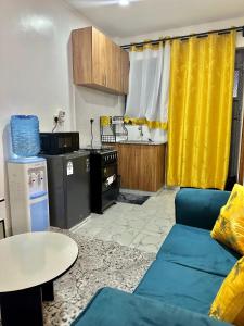 a living room with a blue couch and a table at Gee Kamakis Airbnbs in Ruiru