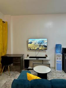 a living room with a blue couch and a table at Gee Kamakis Airbnbs in Ruiru