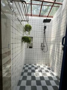 une salle de bain carrelée avec deux plantes en pot au mur dans l'établissement Mon's House, à Cư Chinh