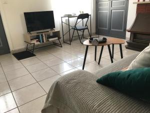 a living room with a couch and a tv at la MAISON de SEVERINE in Abbeville