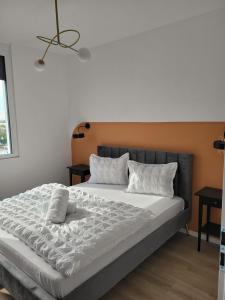 una cama grande con sábanas y almohadas blancas en Sika Platinum Premium Apartment- private parking, en Arad