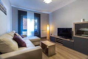 un salon avec un canapé blanc et une télévision dans l'établissement Ferrobús, à Zamora