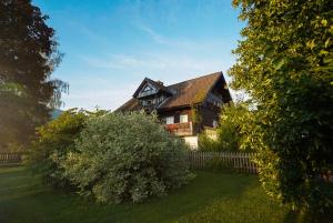 a large house with a fence in a yard at Bio Bauernhof Leitenmüller in Ramsau am Dachstein