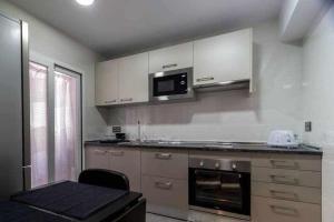 une cuisine avec une cuisinière et un micro-ondes dans l'établissement Ferrobús, à Zamora