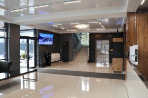 a lobby with a staircase and a television on the wall at Sobkoff in Khmelʼnytsʼkyy