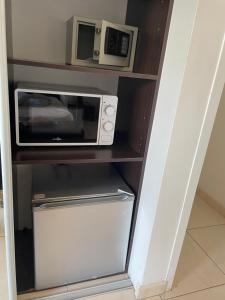 eine Mikrowelle auf einem Regal in der Unterkunft Grand Studio "Figuières" - Domaine Ciel et Mer in Ensuès-la-Redonne