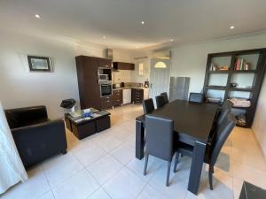 eine Küche und ein Esszimmer mit Tisch und Stühlen in der Unterkunft Grand Studio "Figuières" - Domaine Ciel et Mer in Ensuès-la-Redonne