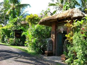 a small brick house with a grass roof at Pondok Pisces Bungalows Balian Beach in Selemadeg