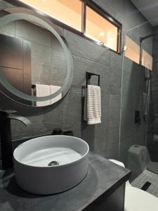 a bathroom with a white sink and a mirror at Ocean Dream Apartment E2-A3 in San Juan del Sur +6 photos