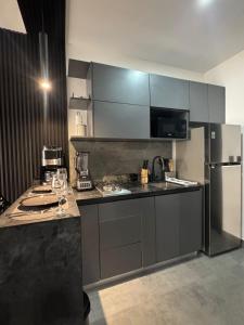 a kitchen with a refrigerator and a counter with wine glasses at Ocean Dream Apartment E2-A3 in San Juan del Sur