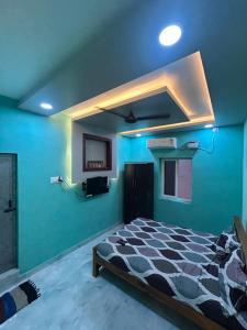 Cette chambre bleue comprend un lit et une télévision. dans l'établissement Vacational Home Stay, à Rameswaram 2 autres photos